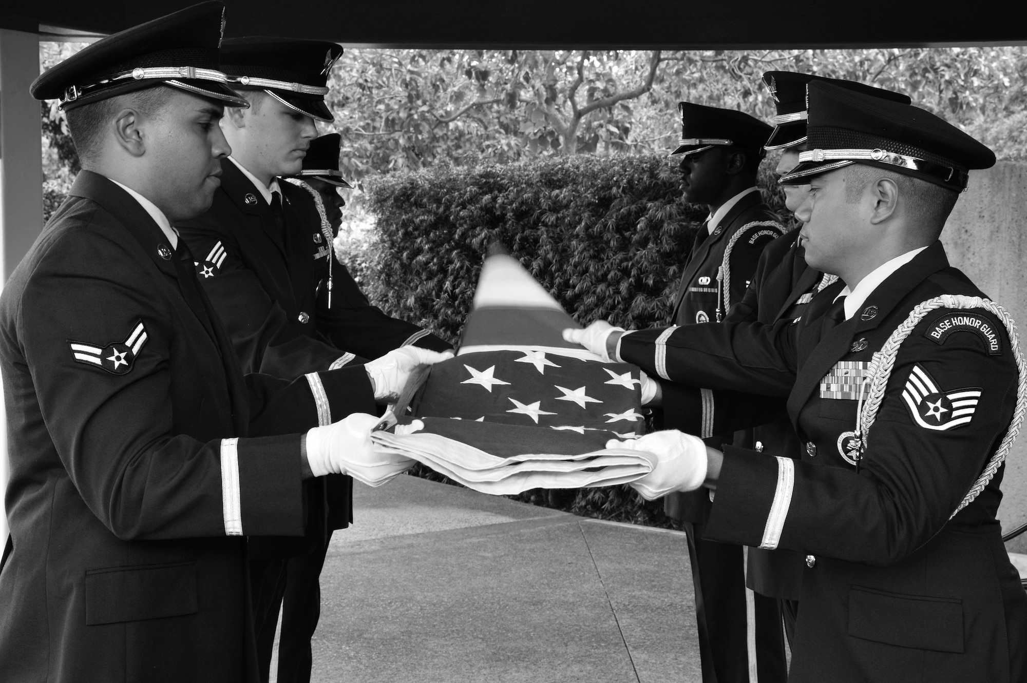 Hickam Honor Guard members unfold a U.S. flag in preparation for the flag to be draped over a casket at the National Memorial Cemetery of the Pacific in Honolulu, Hawaii, Nov. 4, 2014. The Honor Guard members practiced going through a funeral ceremony in order to ensure they execute the actual ceremony with no mistakes. The Hickam Honor Guard is the busiest in the Pacific, and one of the busiest in the Air Force providing the majority of their ceremony support for the Hawaiian Islands. (U.S. Air Force photo by Staff Sgt. Alexander Martinez)