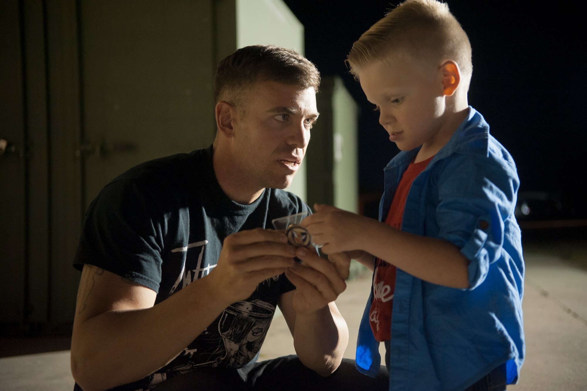 Silas Lanthorn shows his new “little hero” coin to his dad, U.S. Air Force Staff Sgt. Lee Lanthorn, at Moody Air Force Base, Ga., Nov. 5, 2014. Silas received the coin from 822nd Base Defense Squadron leadership for being brave during his father’s recent six month deployment. (U.S. Air Force photo by Andrea Jenkins/Released)