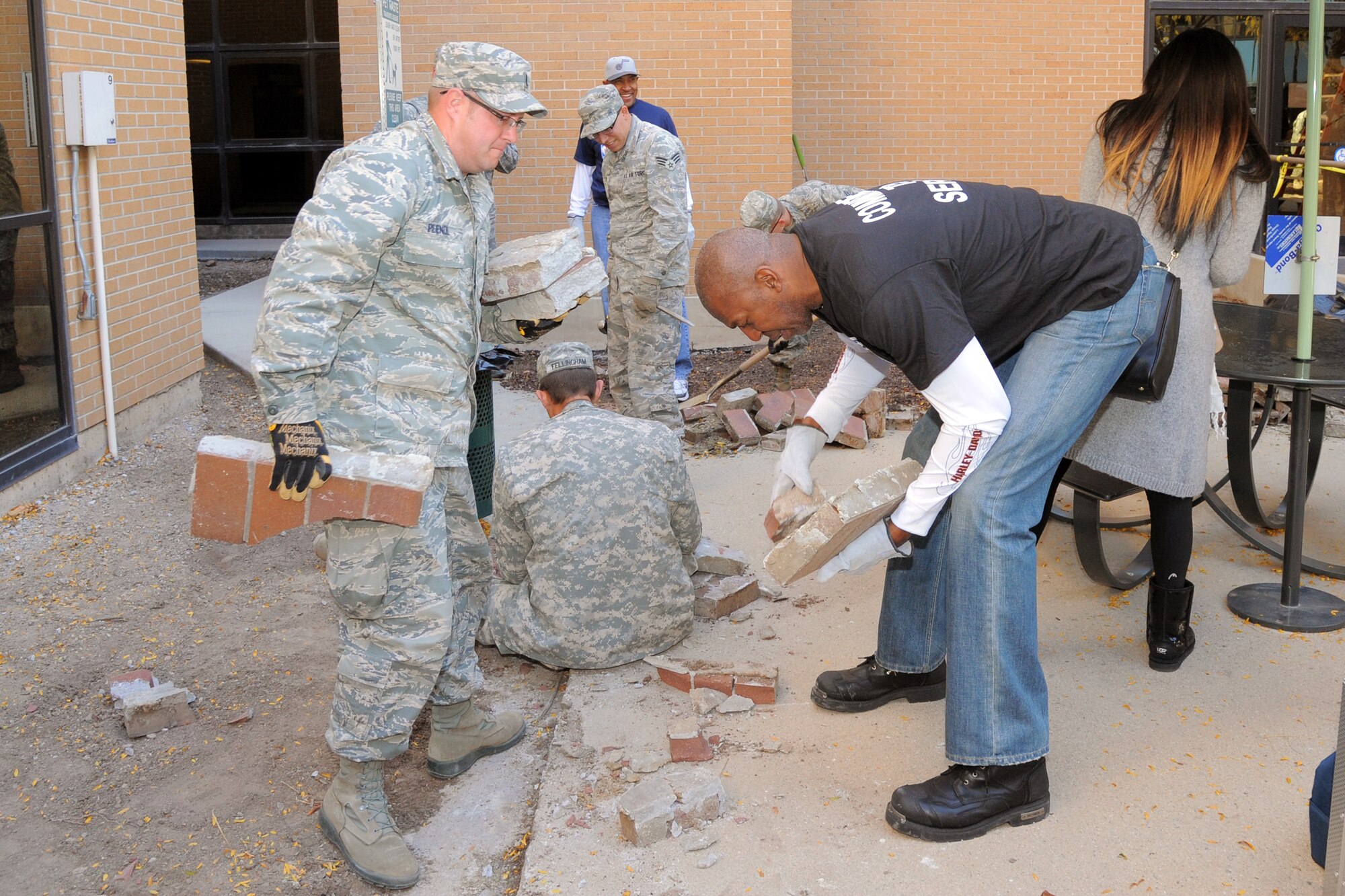 2nd Lt. Matthew Plendl, reservist in the 419th Medical Squadron, and Thurl Bailey, Utah Jazz player from 1983-1991, remove old bricks from the courtyard at the Veteran Affairs Medical Center in Salt Lake City Nov. 6. The community service project saw Plendl and other reservists in the 419th Fighter Wing join volunteers from the Air Force, Marines, Army, and Navy to make a better living space for veterans. (U.S. Air Force photo/Todd Cromar)