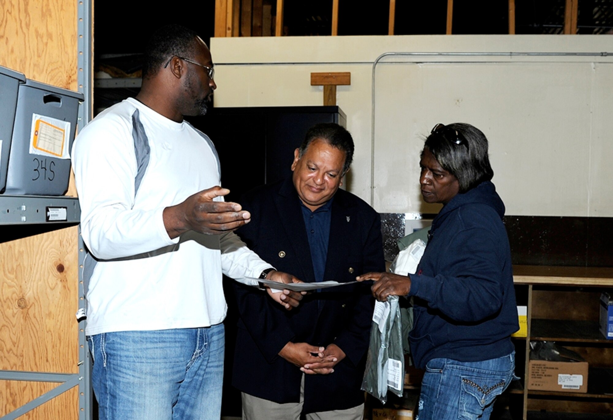 Willie Crawford, 14th Logistics Readiness Squadron Material Handler, left, and Shirley Rush-Forte, 14th LRS Supply Technician, right, go over the flight suit inventory  at Individual Equipment with SES 2 Gilbert Montoya, Air Education and Training Command Director of Logistics, Installations and Mission Support, Nov. 4 at Columbus Air Force Base. Montoya said he and his team were very impressed with Columbus AFB and the 14th FTW during their visit. (U.S. Air Force photo/Elizabeth Owens)