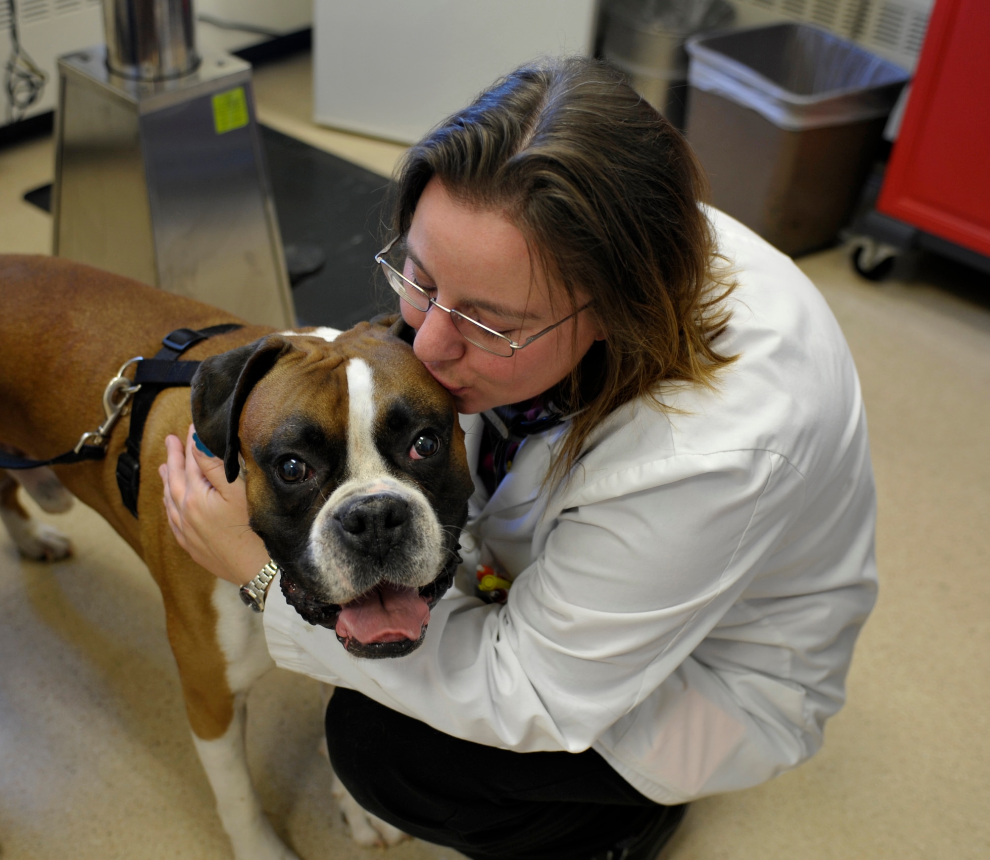 Dannette DeWeese, base veterinarian, shows her love for animals as she gives a kiss to a dog named Achilles Holbart, Oct. 20, 2014, at the Vet Clinic of Fairchild Air Force Base, Wash. DeWeese has been a practicing veterinarian for nine years and loves giving back and helping animals. (U.S. Air Force photo/Airman 1st Class Taylor Bourgeous)