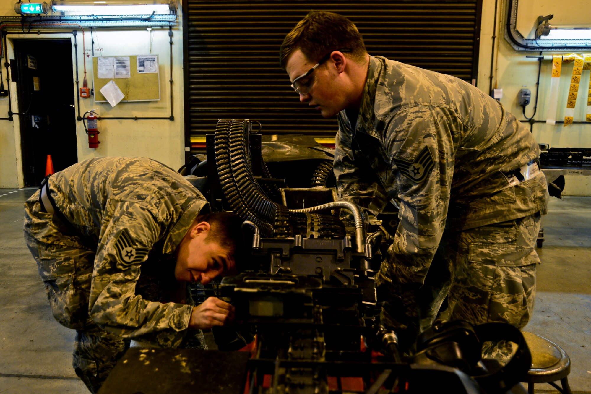 Staff Sgts. Eric Heller and Seth Johnston, 48th Munitions Squadron conventional maintenance crew chiefs, prepare to process the universal ammunition loading system for any missed 20 mm rounds at Royal Air Force Lakenheath, England, Nov. 3, 2014. The 48th MUNS provides all explosives, to include bombs, 20 mm rounds, counter measures, marine markers and small arms, to the fighter squadrons and the rescue squadron. (U.S. Air Force photo by Airman 1st Class Erin R. Babis/Released)