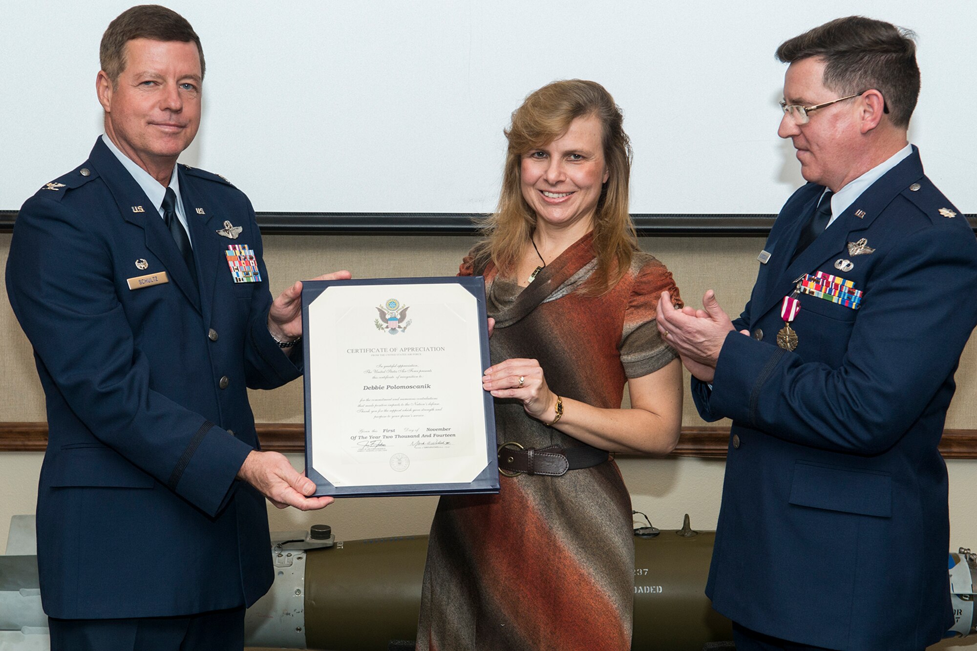 Debbie Polomoscanik is presented the spouse Certificate of Appreciation during a retirement ceremony held for her husband, Lt. Col. Ronald Polomoscanik, Nov. 2, 2014, Barksdale Air Force Base, La. Polomoscanik is the Director of Operations for the 343rd Bomb Squadron and is retiring from the Air Force Reserve. (U.S. Air Force photo by Master Sgt. Greg Steele/Released)