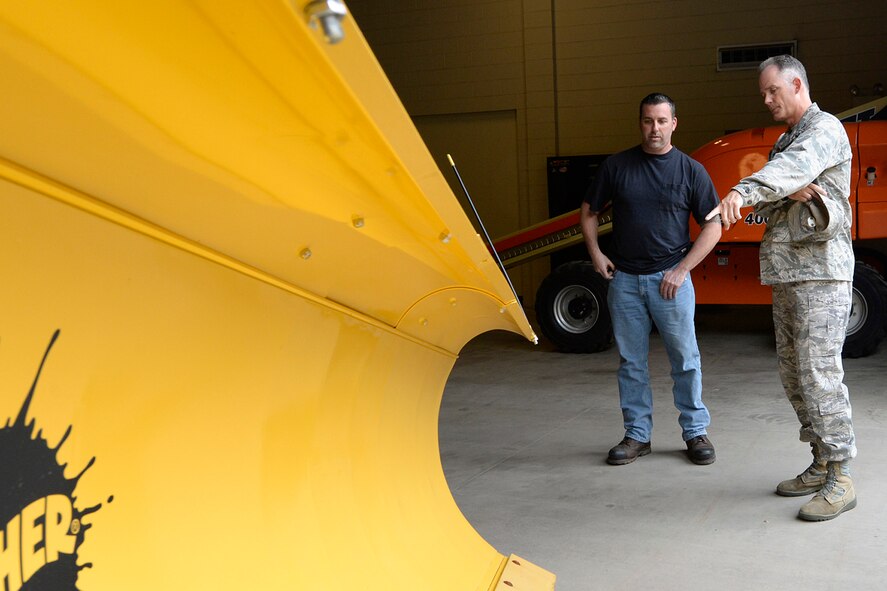 Col. Michael A. Vogel, 66th Air Base Group commander, and Brian Blasingame, Civil Engineering heavy equipment supervisor, discuss procedures to maintaining snow removal equipment during snow storms at the CE Complex, Oct. 28. Any issues regarding base snow removal can be addressed by calling 781-225-2990. (U.S. Air Force photo by Linda LaBonte Britt)