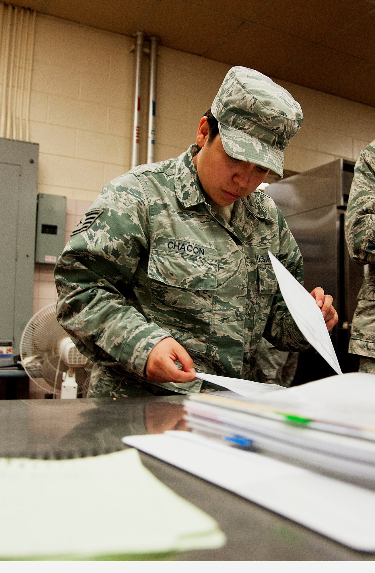 Staff Sgt. Angelica Chacon, 8th Medical Group noncommissioned officer in charge of force health, looks over inspection sheets during a health inspection at the O’Malley Dining Facility Sept. 12, 2014, at Kunsan Air Base, Republic of Korea.  Chacon was recognized by the 8 MDG as their pride of the pack outstanding performer and got a chance to show Wolf and Wolf Chief how she contributes to the Wolf Pack mission. (U.S. Air Force photo by Senior Airman Divine Cox)