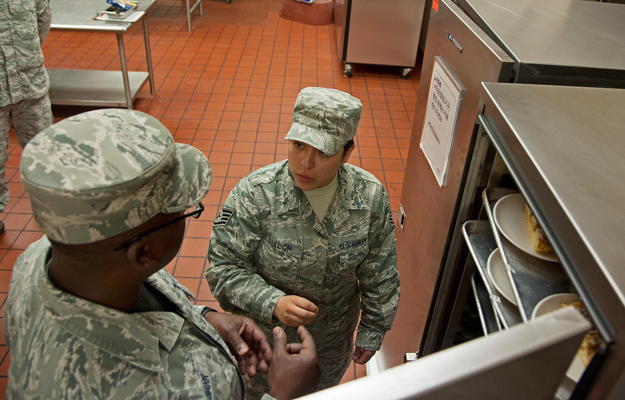 Staff Sgt. Angelica Chacon, 8th Medical Group force health noncommissioned officer in charge of force health, and Chief Master Sgt. Lee “Wolf Chief” Barr, 8th Fighter Wing command chief, inspect the dessert refrigerator during a health inspection at the O’Malley Dining Facility Sept. 12, 2014, at Kunsan Air Base, Republic of Korea.  Chacon was recognized by the 8 MDG as one of their outstanding performers and got a chance to show Wolf and Wolf Chief how she contributes to the Wolf Pack mission. (U.S. Air Force photo by Senior Airman Divine Cox)