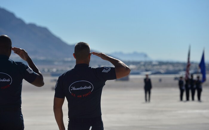 Members of the U.S. Air Force Aerial Demonstration Team, or Thunderbirds, salute the colors during the Nellis Open House opening ceremony, Nov. 7, 2014, at Nellis Air Force Base, Nev. The Open House will feature numerous aircraft representing America's aviation history will be on display alongside some of the nation's newest military aircraft, such as the P-51 Mustang, B-1 Lancer, F-22 Raptor and many others. (U.S. Air Force photo by Tech. Sgt. Nadine Barclay)