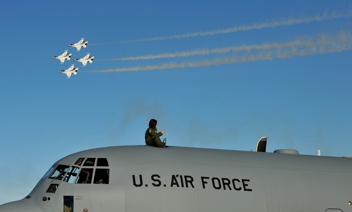 The aircrew of a C-130J Hercules sit atop the aircraft to watch the practice performance of the U.S. Air Force Aerial Demonstration Team, or Thunderbirds, Nov. 7, 2014, at Nellis Air Force Base, Nev. Approximately 100 military and civilian aircraft are expected to be on display as well as several military air demonstration teams, warbirds, and some of the nation's top civilian air performers will participate. (U.S. Air Force photo by Tech. Sgt. Nadine Barclay)