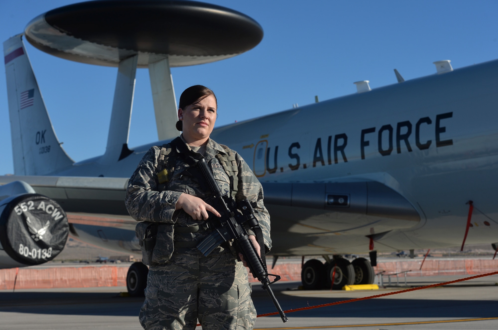 A security forces Airmen stands guard in front of an E-3 Sentry airborne warning and control system, or AWACS, at the Nellis Open House Nov. 7, 2014, at Nellis Air Force Base, Nev. The AWACS provides situational awareness of friendly, neutral and hostile activity, command and control of an area of responsibility, battle management of theater forces, all-altitude and all-weather surveillance of the battle space, and early warning of enemy actions during joint, allied, and coalition operations. (U.S. Air Force photo by Tech. Sgt. Nadine Barclay)