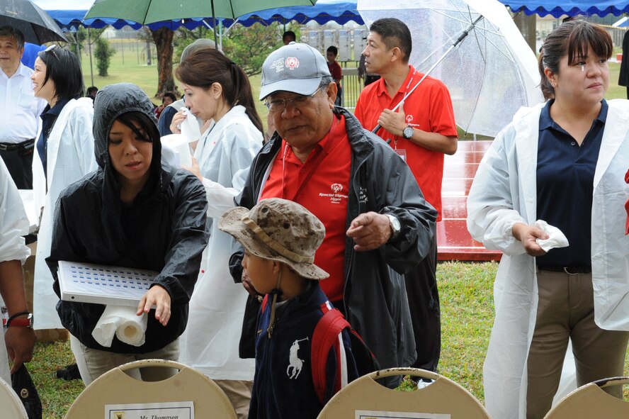Sayaka Kawatake, 18th Wing Public Affairs community relations representative, assists a local national at the Kadena Special Olympics on Kadena Air Base, Japan, Nov. 8, 2014. KSO is a one-day sporting and entertainment event with approximately 950 special needs athletes and artists participating in a day of competition, music and special recognition. (U.S. Air Force photo by Airman 1st Class Zackary A. Henry/Released)