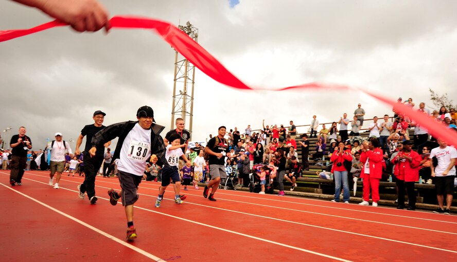 Japanese athletes and their helpers run the 30-meter dash during the Kadena Special Olympics at the Kadena Air Base, Japan, Nov. 8, 2014. Approximately 950 athletes attended KSO festivities, including approximately 2,500 American volunteers and language interpreters, along with senior officials from the Government of Japan, Okinawa Prefectural Government, local communities and the U.S. (U.S. Air Force photo by Naoto Anazawa/Released)