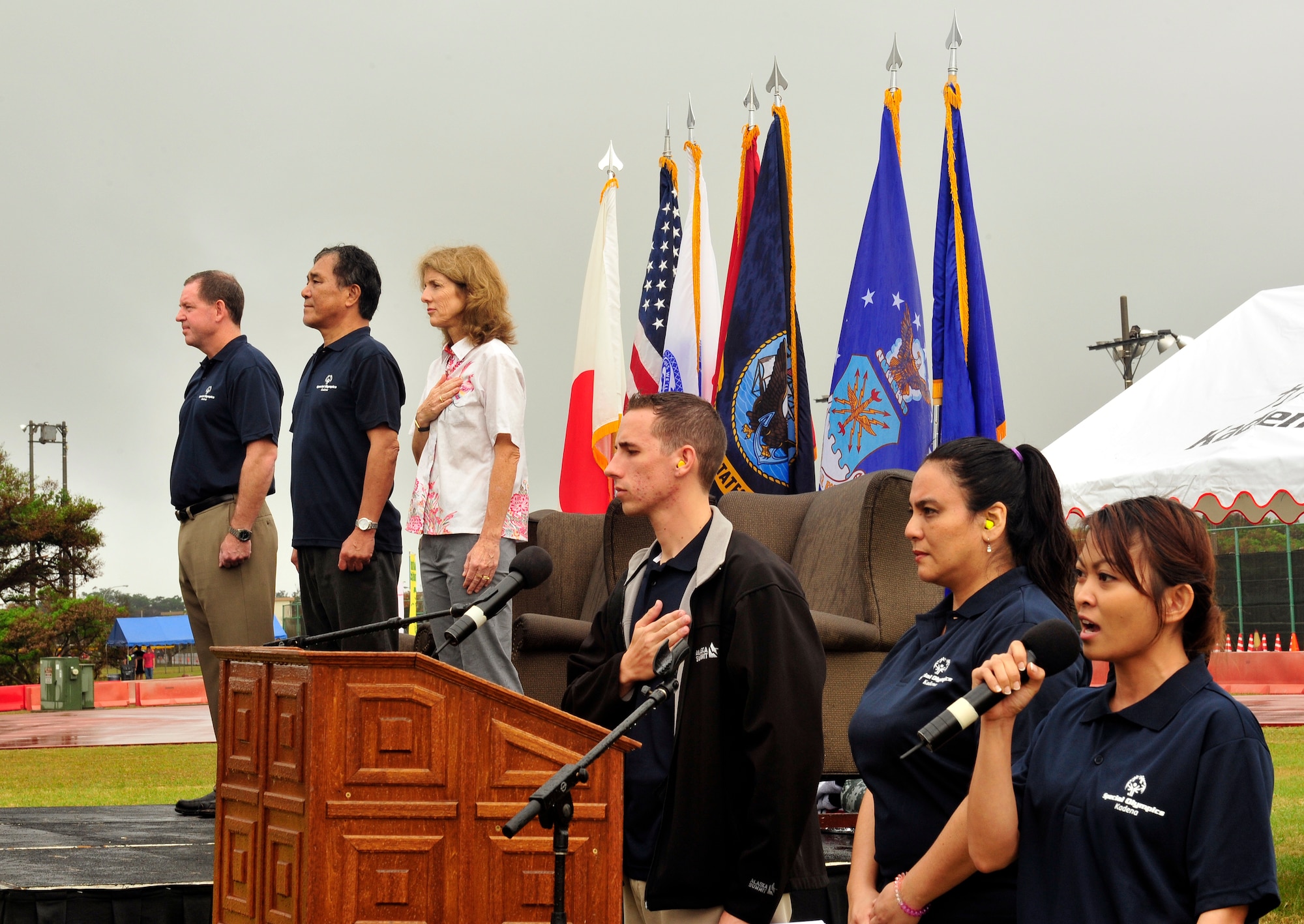 U.S. Navy Petty Officer 3rd Class Roxanne Diaz, Yokosuka Site Okinawa naval supply fleet logistics center, sings the U.S. national anthem at the opening of the 15th annual Kadena Special Olympics, Kadena Air Base, Japan, Nov. 8, 2014. KSO was established by the 18th Wing commander and began in 2000 as an avenue to build relations with the local communities and government representatives while providing a meaningful activity for the special needs children and adults on the island. (U.S. Air Force photo by Naoto Anazawa/Released)