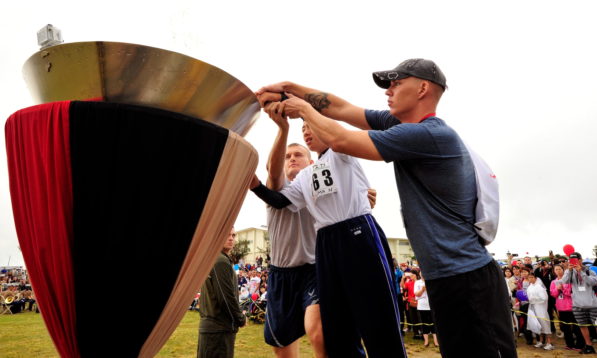 Yuma Nakachi, the torch runner of the 15th annual Kadena Special Olympics, lights the KSO torch during the event's opening ceremony on Kadena Air Base, Japan, Nov. 8, 2014. KSO is a one-day sporting and entertainment event with approximately 950 special-needs athletes and artists participating in a day of competition, music and special recognition. (U.S. Air Force photo by Naoto Anazawa/Released)