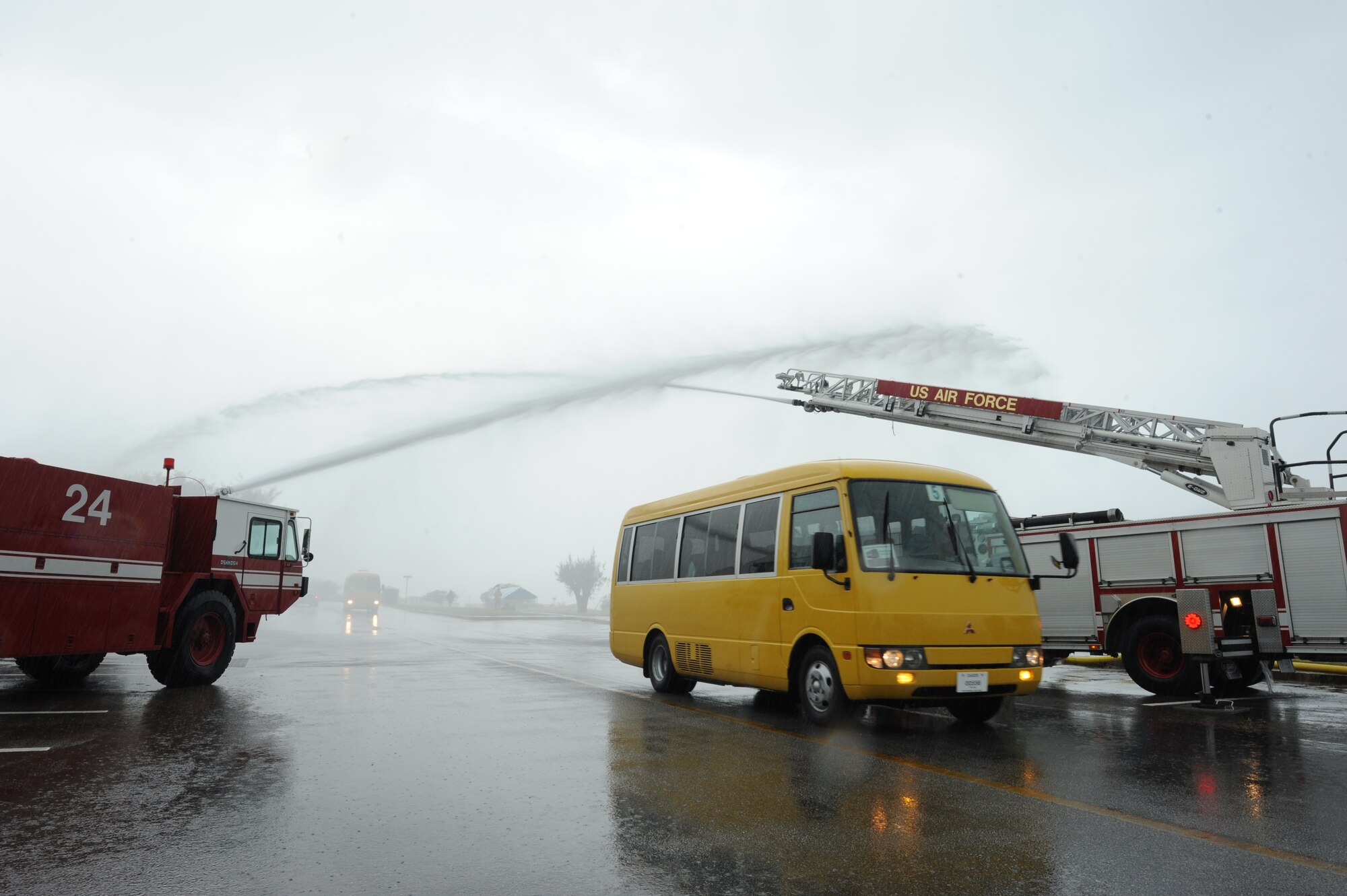 U.S. Air Force firefighters from the 18th Civil Engineer Squadron spray water over buses filled with Special Olympics athletes as they arrive at the Kadena Special Olympics on Kadena Air Base, Japan, Nov. 8, 2014. KSO has been conducted by Kadena every year since 2000 and was established by the 18th Wing commander. KSO features wholesome sporting and entertainment, and the communities involved stand together to support and enable it. (U.S. Air Force photo by Airman 1st Class Stephen G. Eigel/Released)