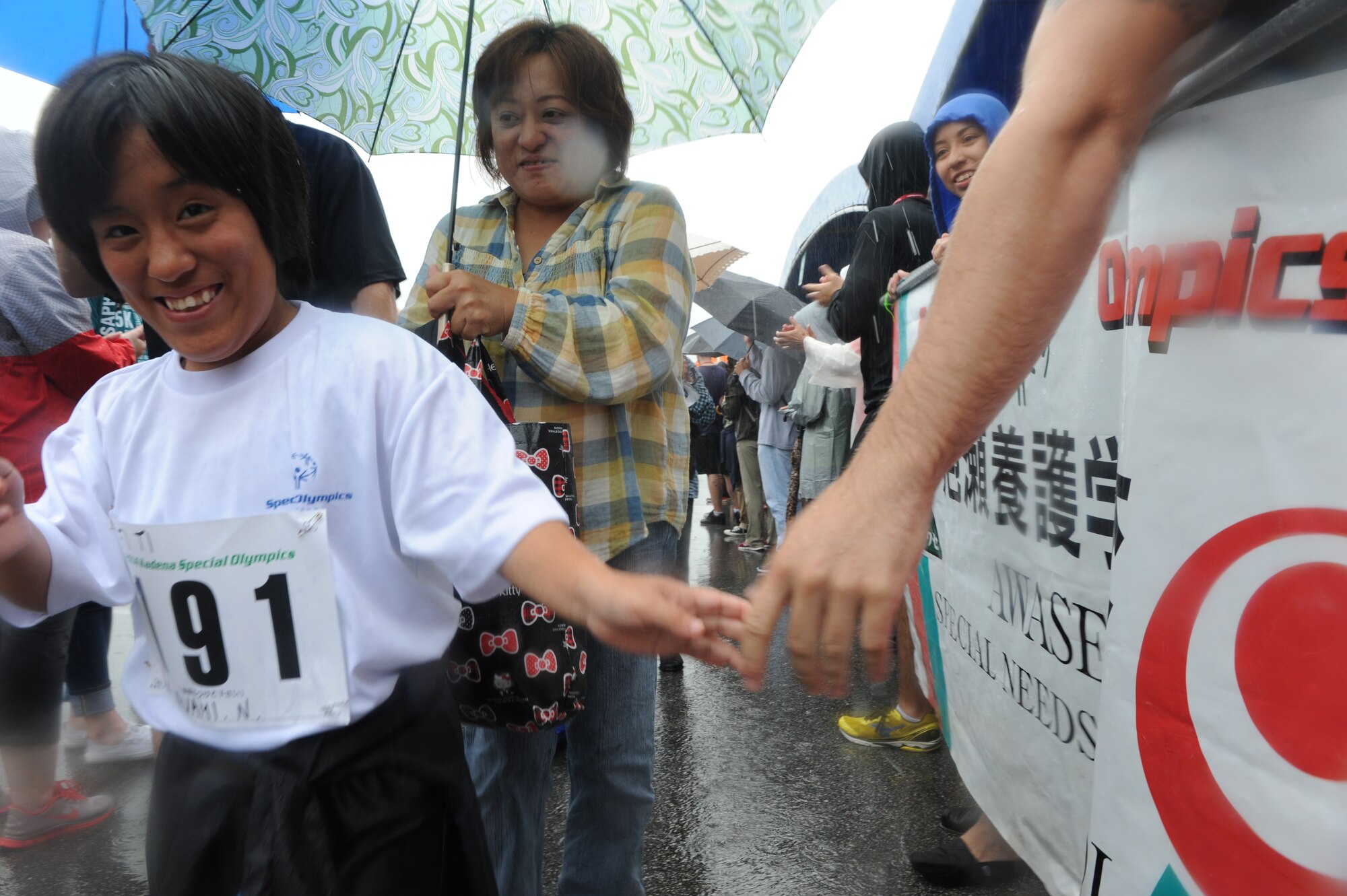 Nakama Nanami from the Nago Special Needs School greets volunteers at the Kadena Special Olympics on Kadena Air Base, Japan, Nov. 8, 2014. KSO began in 2000 with approximately 400 athletes and 600 volunteers as an 18th Wing community goodwill initiative to strengthen Japan-U.S. relationships. (U.S. Air Force photo by Airman 1st Class Stephen G. Eigel/Released)