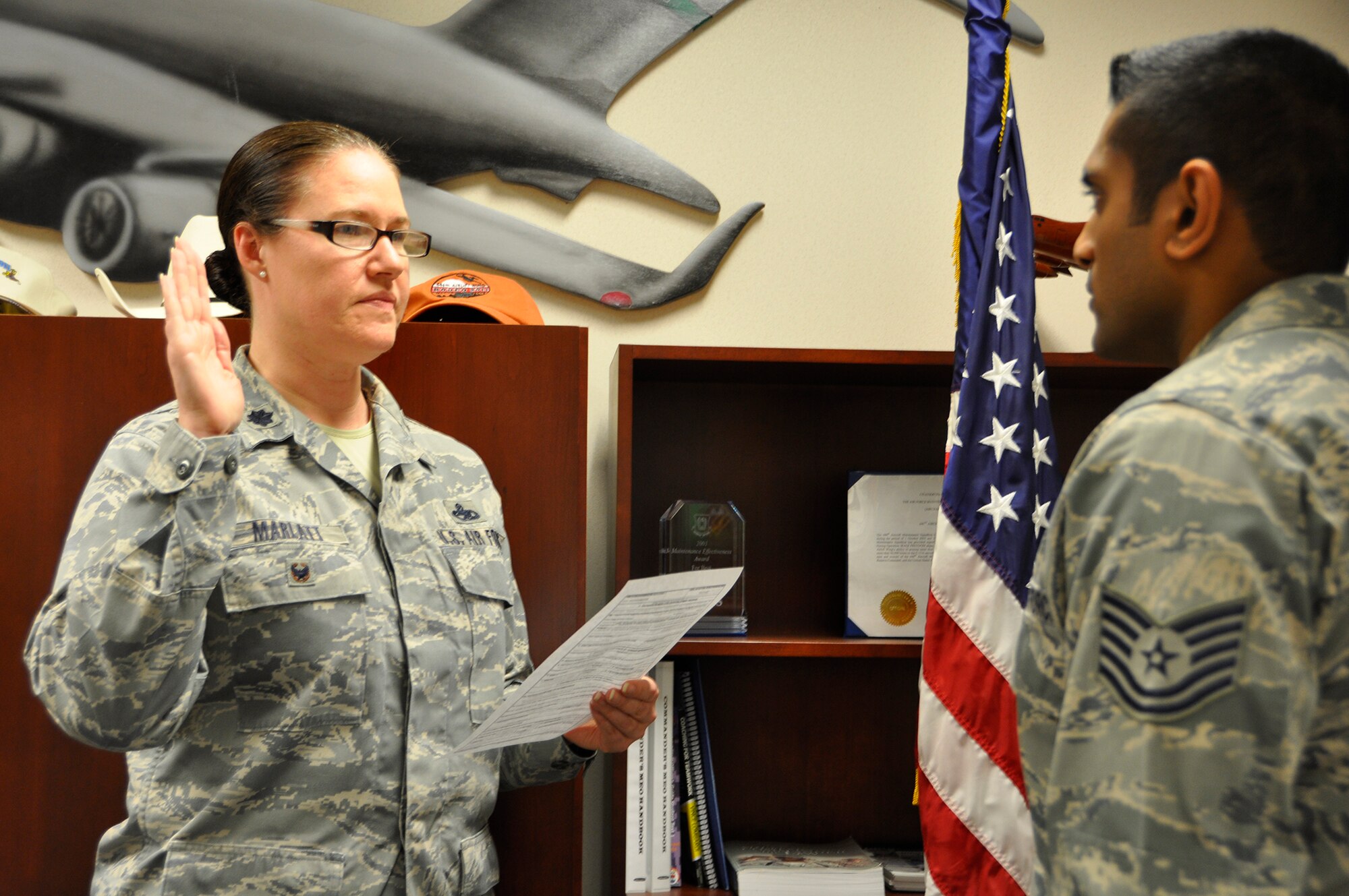 From left, Lt. Col. Madalyn Marlatt, 446th Aircraft Maintenance Squadron operations officer, re-enlists Tech. Sgt. Amitesh Sami, 446th AMXS crew chief, Nov. 9 in Bldg. 1145. Marlatt's employer, Capital One of McLean, Virginia, recently received the Secretary of Defense Employer Support Freedom Award.