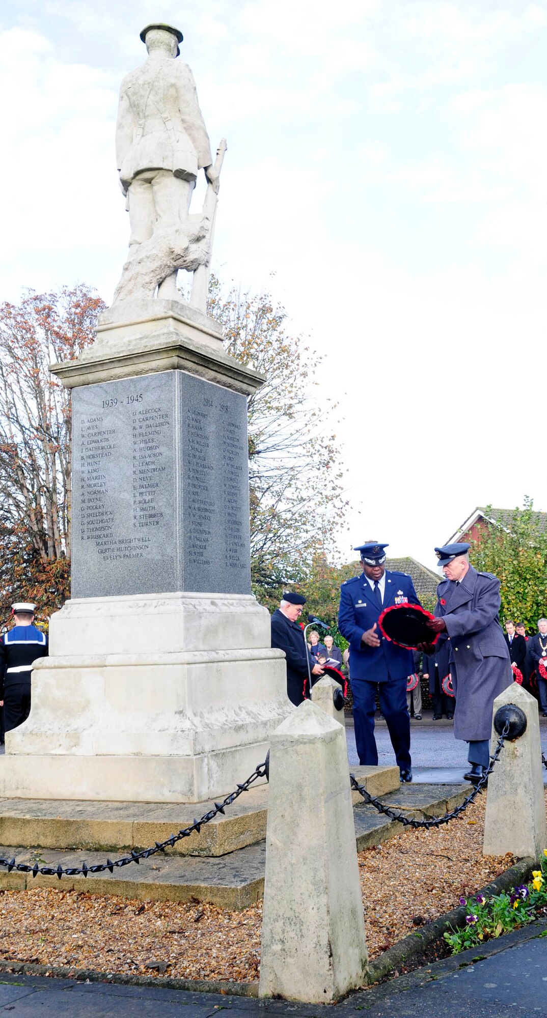U.S. Air Force Col. Earl Scott, left with wreath, 100th Maintenance Group commander, and Royal Air Force Sqdn. Ldr. Richard Fryer, right, RAF Mildenhall Station commander, lay a poppy wreath during a Remembrance Day ceremony Nov. 9, 2014, in Mildenhall, Suffolk, England. The poppy was chosen as the symbol of remembrance because many British soldiers lost their lives in the poppy fields of Flanders, Belgium, during World War I. (U.S. Air Force photo by Karen Abeyasekere/Released)