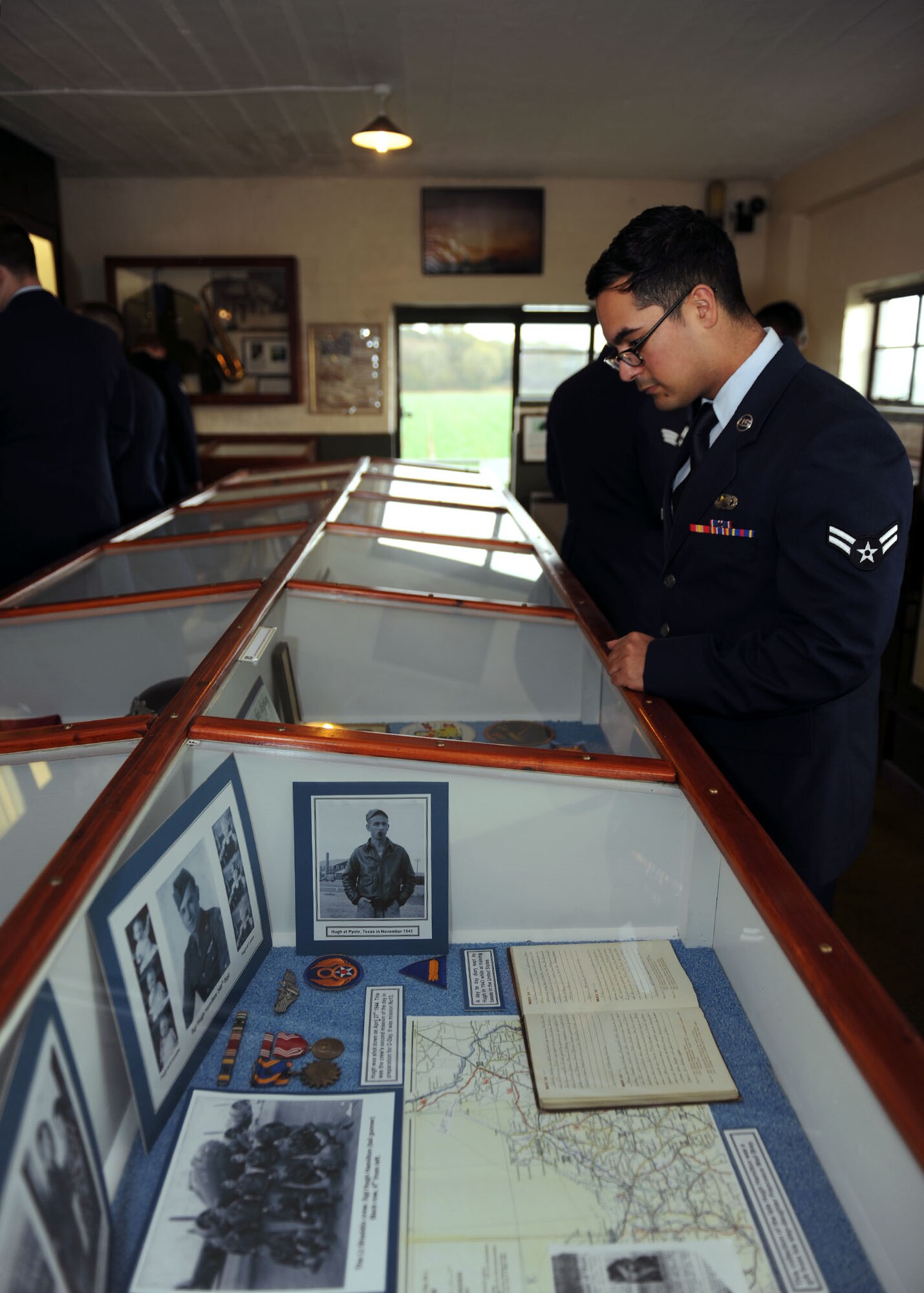 U.S. Air Force Airman 1st Class Xavier Gurrola, 100th Operations Group Commander’s Support Staff journeyman from Covina, Calif., looks at a display Nov. 9, 2014, at the 100th Bomb Group Memorial Museum at RAF Thorpe Abbotts, England. Team Mildenhall Airmen toured the museum to reflect on their heritage after marching in a nearby Remembrance Day ceremony. (U.S. Air Force photo by Airman 1st Class Preston Webb/Released)
