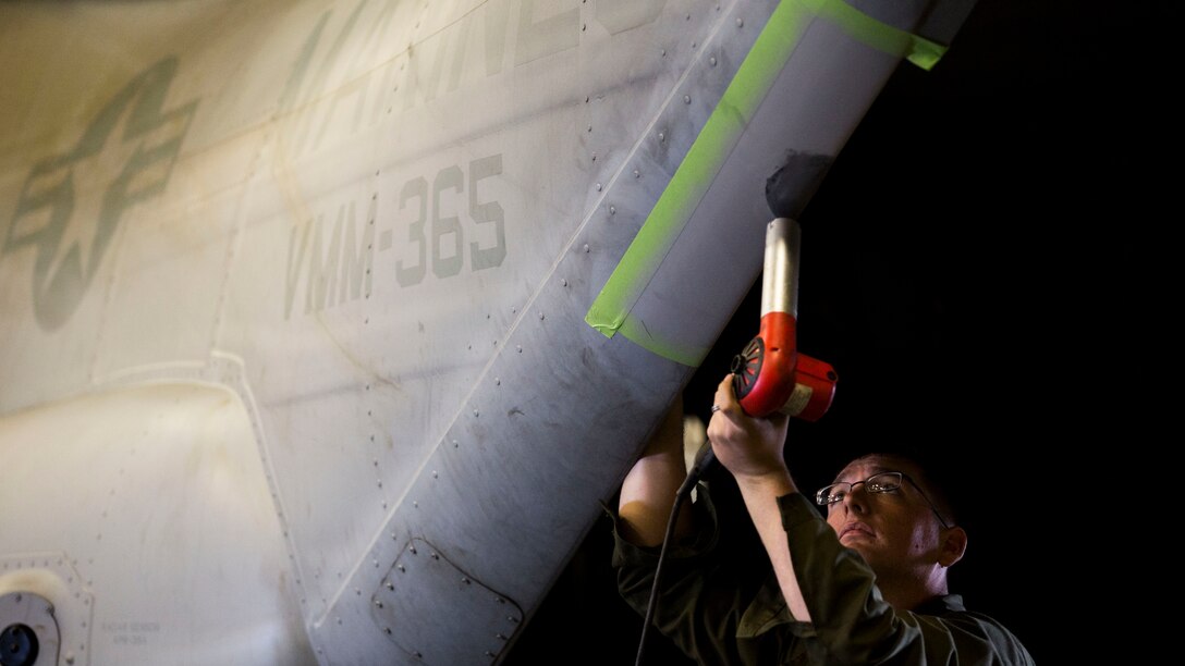 Lance Cpl. Tyler Clinton, a tiltrotor airframe mechanic with Marine Medium Tiltrotor Squadron 365 (Reinforced), 24th Marine Expeditionary Unit, uses a blow dryer to dry a carbon fiber patch on an MV-22B Osprey in the hangar bay of the USS Iwo Jima, Oct. 31, 2014. Maintenance on 24th MEU aircraft is near constant in order to maintain a high state of flight readiness. The 24th MEU is participating in Bold Alligator, an exercise intended to improve Navy and Marine Corps amphibious core competencies. 