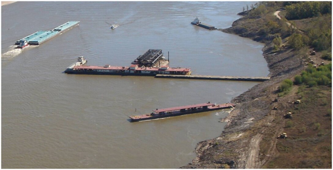 Barge traffic navigates Mississippi River while Mat Sink Unit does revetment work at Helena, Arkansas.