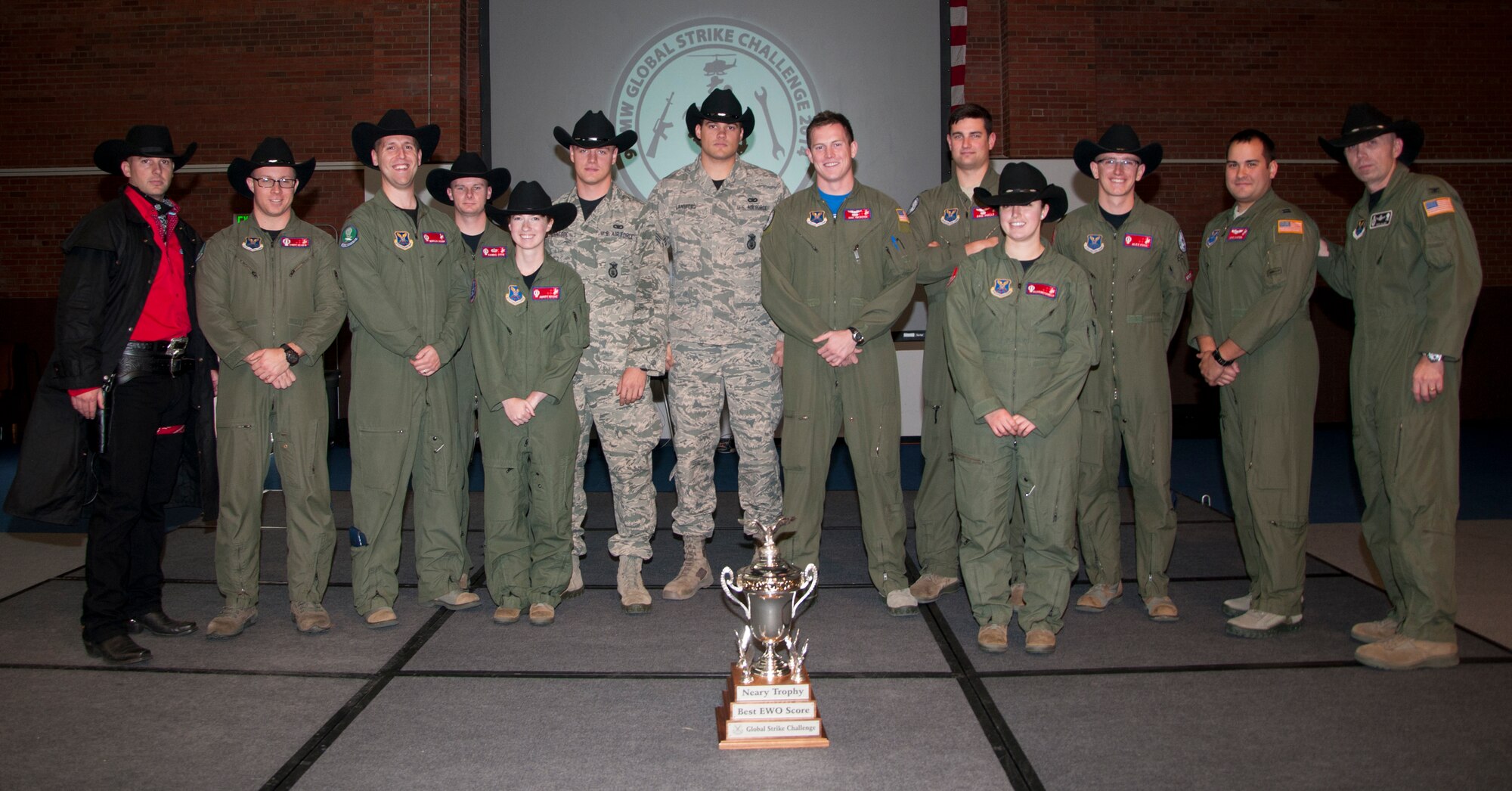 The Warren Wrangler, the 90th Missile Wing's official Global Strike Challenge Mascot, poses with the 90th Operations Group 2014 Global Strike Challenge competitors and Col. Ronald Allen, 90th OG commander, Nov. 7, 2014, in the Fall Hall Community Center on F.E. Warren Air Force Base, Wyo. The 321st Missile Squadron missile combat crew consisting of  1st Lt. Corey Elder, 320th MS missile combat crew commander, and Second Lt. Nicholas Vaughn, 321st Missile Squadron deputy missile combat crew commander, won the Neary Trophy for best emergency war orders performance. (U.S. Air Force photo by Senior Airman Jason Wiese)
