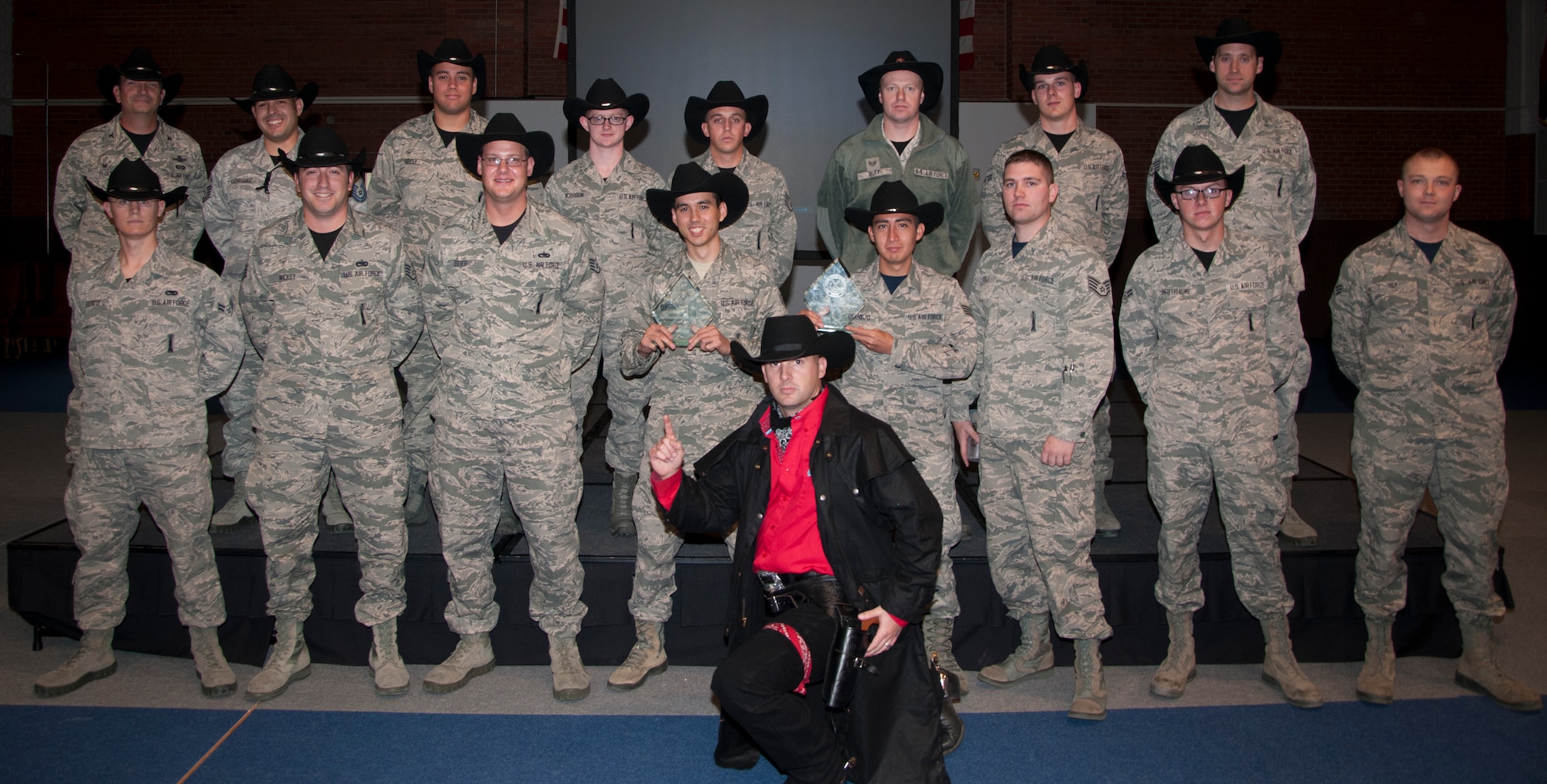 The Warren Wrangler, the 90th Missile Wing's official Global Strike Challenge Mascot,  poses with the 90th Maintenance Group 2014 Global Strike Challenge competitors and Col. Trevor Flint, 90th MXG commander, Nov. 7, 2014, in the Fall Hall Community Center on F.E. Warren Air Force Base, Wyo. The 90th Maintenance Operations Squadron Electronics Laboratory and the 90th Munitions Squadron teams won the awards for best team in their respective categories. (U.S. Air Force photo by Senior Airman Jason Wiese)