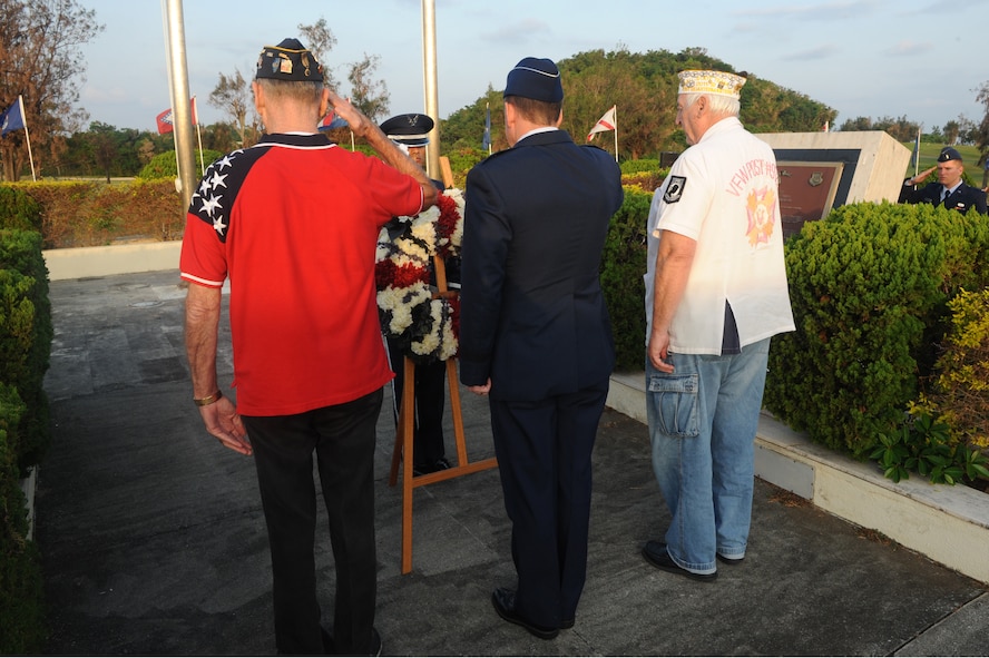 Members of Veterans of Foreign Wars Post 9723 and U.S. Air Force Brig. Gen. James B. Hecker, 18th Wing commander, salute the Prisoners of War/Missing in Action Wreath after placing it at the base of the flag poles on Kadena Air Base, Japan, Nov. 11, 2014. During the ceremony, members from each U.S. military branch on Okinawa came together to recognize the sacrifices made by all U.S. veterans, past and present. (U.S. Air Force photo by Airman 1st Class Stephen G. Eigel/Released)