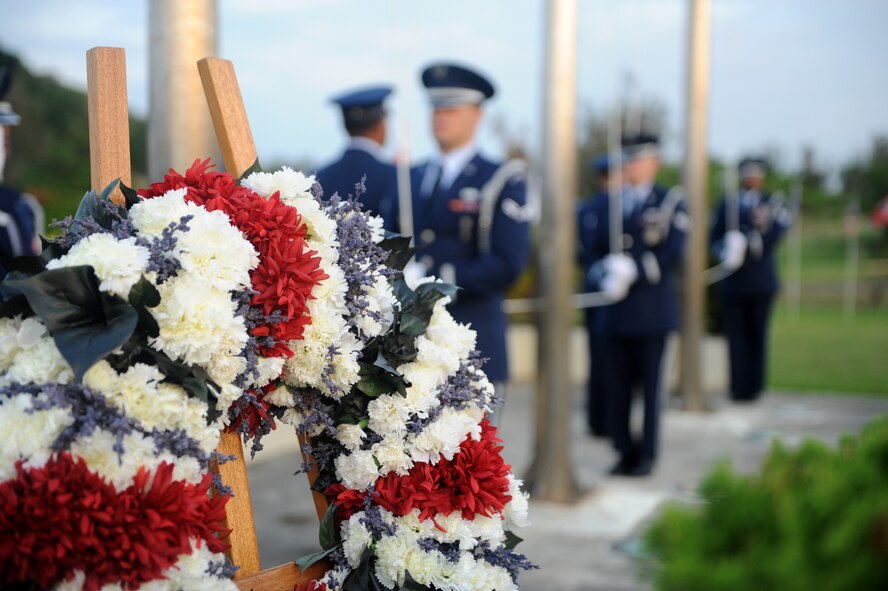 The Prisoners of War/Missing in Action wreath sits at the base of the flag poles in front of the 18th Wing headquarters building on Kadena Air Base, Japan, Nov. 11, 2014. During the ceremony, members from each U.S. military branch on Okinawa came together to recognize the sacrifices made by all U.S. veterans, past and present. (U.S. Air Force photo by Airman 1st Class Stephen G. Eigel/Released)