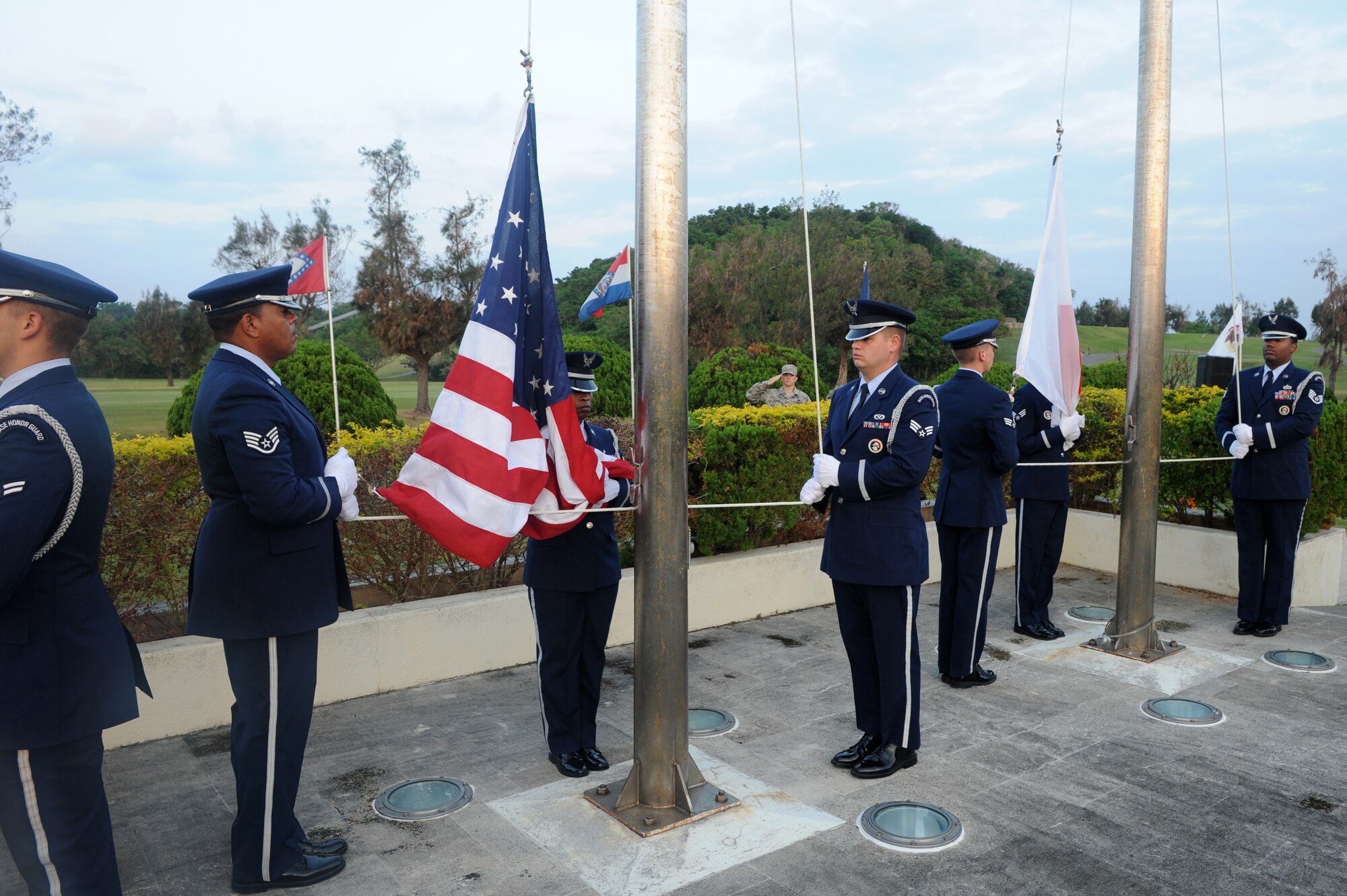 Members of the Kadena Honor Guard raise the NATO, American and Japanese flags during reveille at a Veterans Day ceremony on Kadena Air Base, Japan, Nov. 11, 2014. Following reveille and the Japanese and American national anthems, each military branch recited their creed in honor of those who have served in the United States military followed by a speech from the 18th Wing commander. (U.S. Air Force photo by Airman 1st Class Stephen G. Eigel/Released)