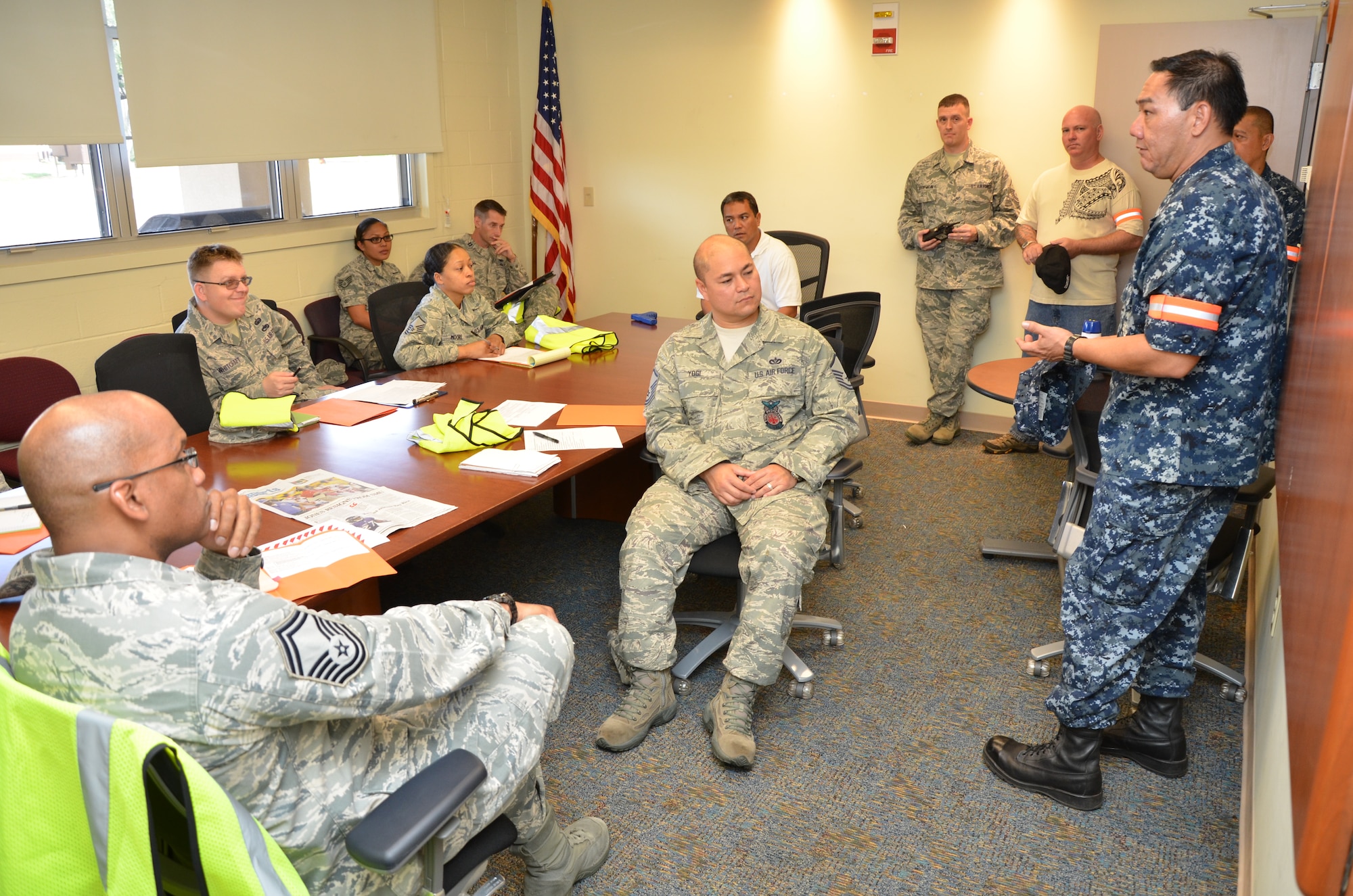 From right, Master-at-Arms Second Class Darrell Jones, a police officer with the Honolulu Police Department (HPD) and a reservist with the Naval Security Force, Naval Intelligence Operations Center, Schoefield Barracks, Hawaii, leads a debrief after an active shooter exercise with members of the 624th Regional Support Group’s Wing Inspection Team (seated, in uniform) who observed the scenario, Joint Base Pearl Harbor-Hickam, Hawaii, Sept. 9, 2014. Four fulltime HPD officers and one Department of Defense police officer shared their expertise in making the exercise as realistic as possible. (U.S. Air Force photo by Tech. Sgt. Phyllis Keith)