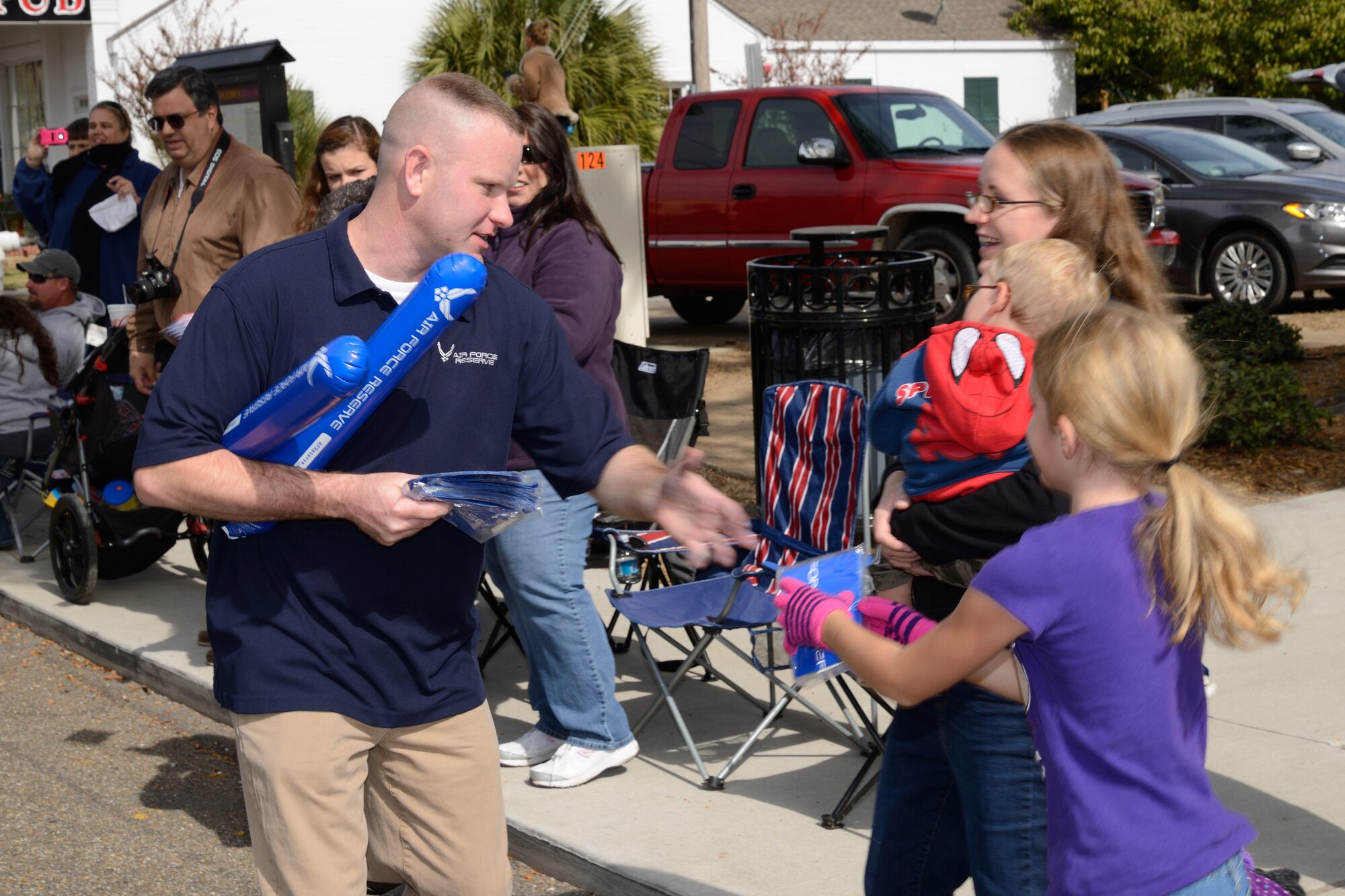 Master Sgt. Clayton Callahan, 403rd Wing senior recruiter, gives an Air Force Reserve balloon to a young spectator during the Gulf Coast Veterans Parade Nov. 8 in Biloxi, Mississippi. Members of the 403rd Wing from Keesler Air Force Base, Mississippi, guided Lil' Bill, a mock C-130J aircraft, down the road during the event. Hundreds of people turned out to view the procession of floats, bands and marching units to show their appreciation for members of the U.S. Armed Forces. (U.S. Air Force photo/Tech. Sgt. Ryan Labadens)