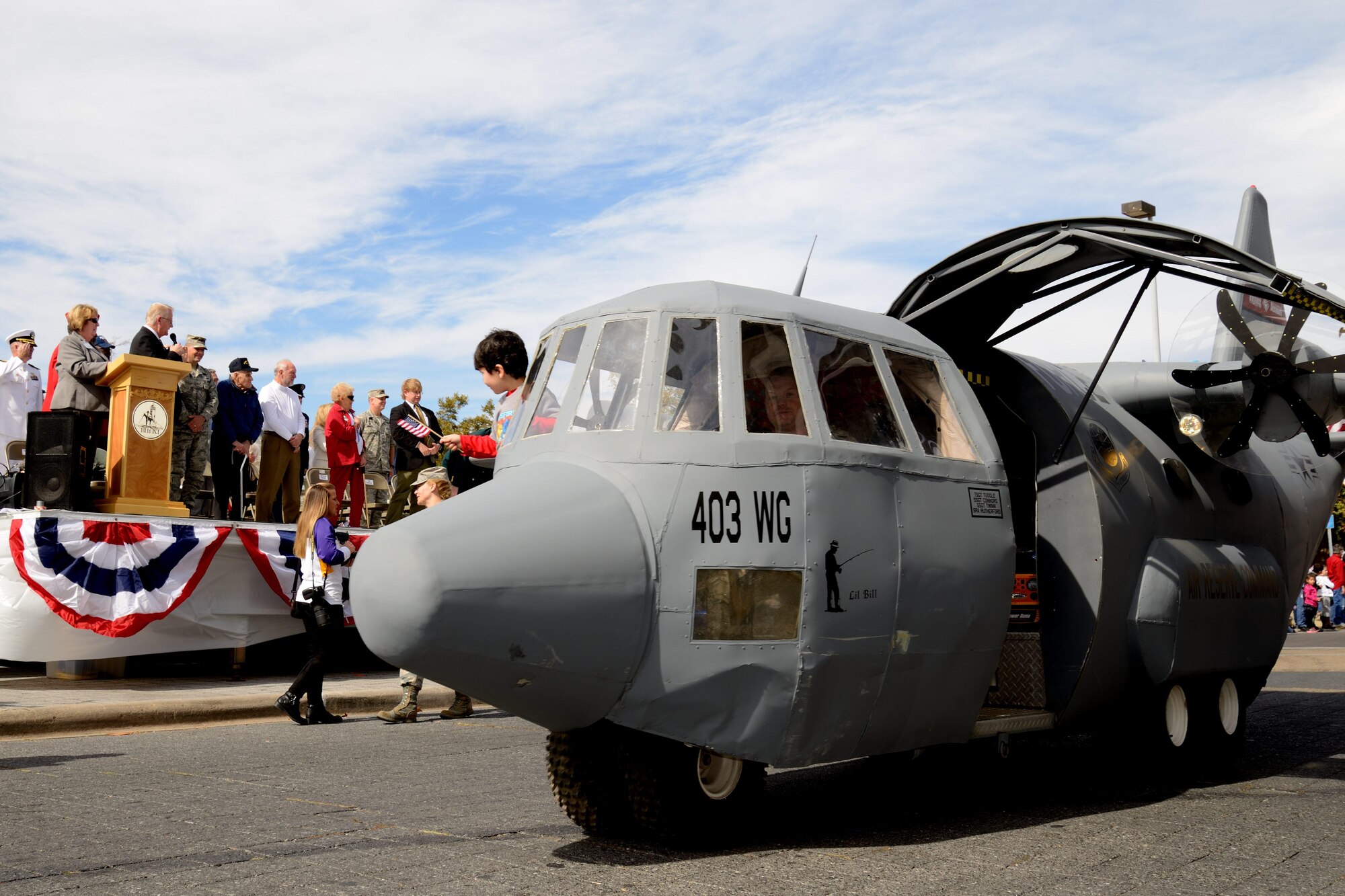 Wyatt Lamar, son of Master Sgt. Brian Lamar, 403rd Wing public affairs noncommissioned officer in charge, rides in Lil' Bill past city hall in Biloxi, Mississippi during the Gulf Coast Veterans Parade Nov. 8. Members of the 403rd Wing from Keesler Air Force Base, Mississippi, guided Lil' Bill, a mock C-130J aircraft, down the road during the event. Hundreds of people turned out to view the procession of floats, bands and marching units to show their appreciation for members of the U.S. Armed Forces. (U.S. Air Force photo/Tech. Sgt. Ryan Labadens)