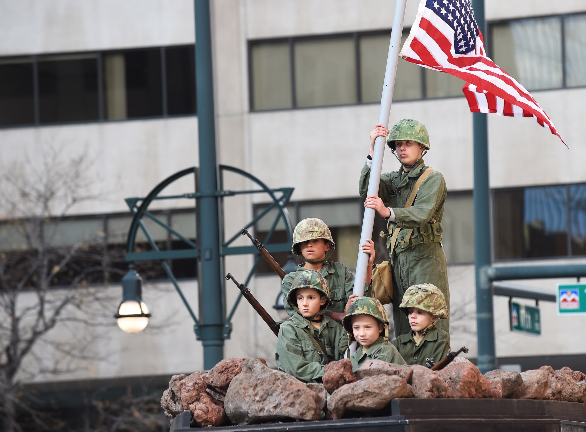 A group of boys re-enact the photo of the American flag being raised on Iwo Jima during the Veteran’s Day Parade, hosted by the Colorado Veterans Project, Nov. 8, 2014, in Denver. The parade consisted of more than 75 groups honoring American veterans by highlighting each American war, beginning with the Revolutionary War and ending with Operation Iraqi Freedom. (U.S. Air Force photo by Airman 1st Class Samantha Saulsbury/Released)