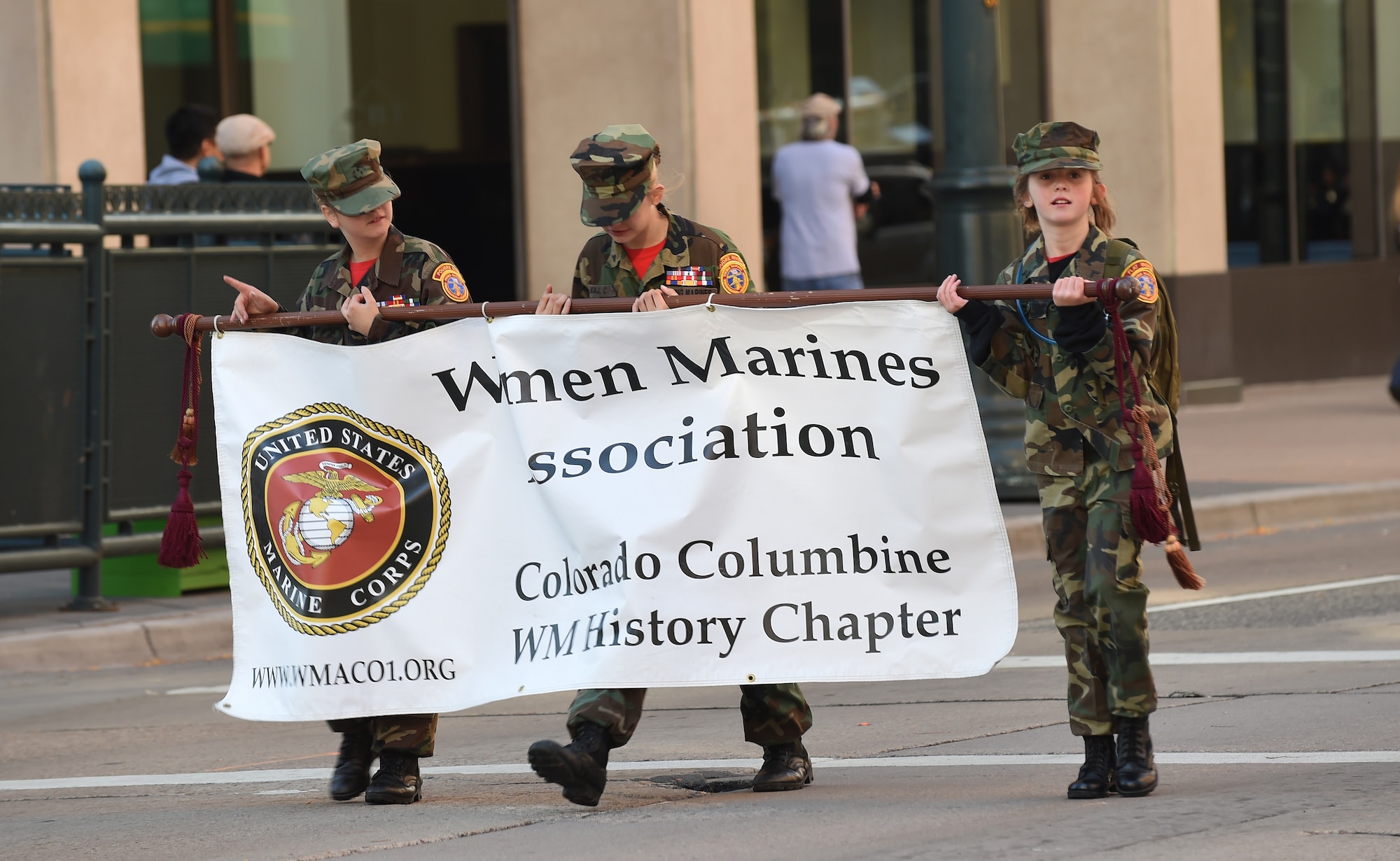 A group of girls hold a Women Marines Association banner during the Veteran’s Day Parade, hosted by the Colorado Veterans Project, Nov. 8, 2014, in Denver. The parade consisted of more than 75 groups honoring American veterans by highlighting each American war, beginning with the Revolutionary War and ending with Operation Iraqi Freedom. (U.S. Air Force photo by Airman 1st Class Samantha Saulsbury/Released)