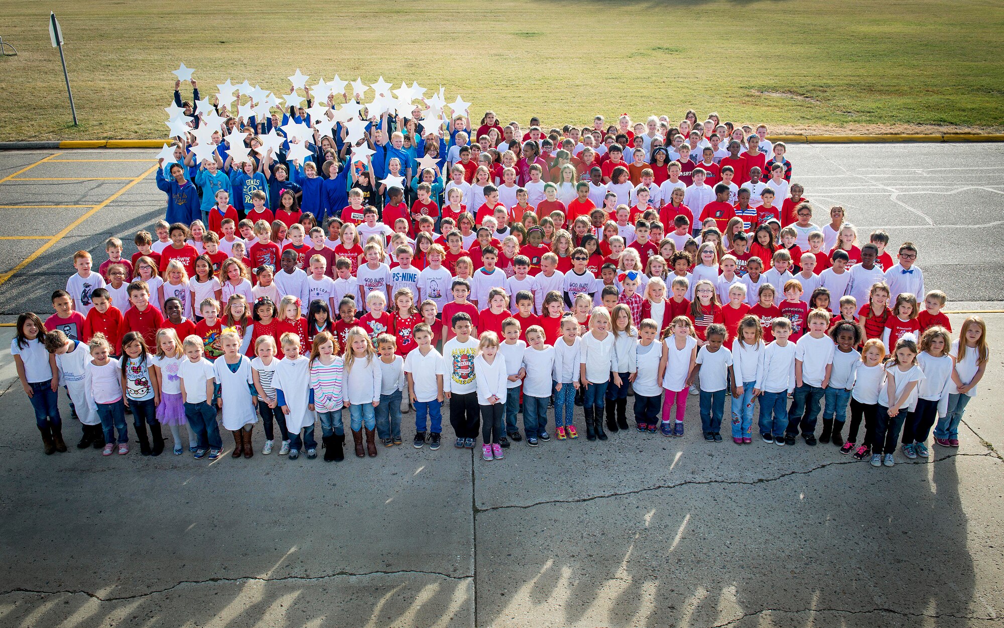 North Plains Elementary School students pose in the shape of the U.S. flag on Minot Air Force Base, N.D., Nov. 6, 2014. The students, ranging from kindergarten to sixth grade, wore red, white and blue shirts to represent the colors of the flag in honor of Veteran’s Day. (U.S. Air Force photo/Airman 1st Class Sahara L. Fales)