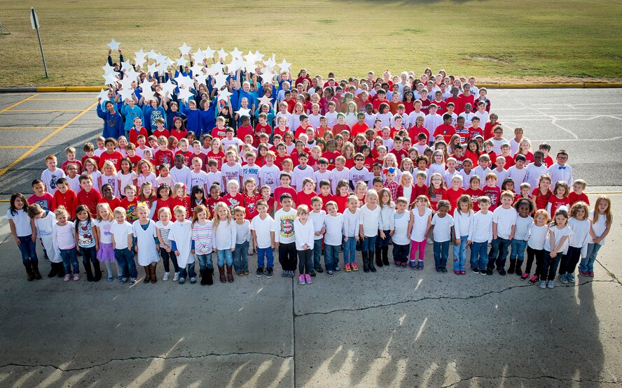 North Plains Elementary School students pose in the shape of the U.S. flag on Minot Air Force Base, N.D., Nov. 6, 2014. The students, ranging from kindergarten to sixth grade, wore red, white and blue shirts to represent the colors of the flag in honor of Veteran’s Day. (U.S. Air Force photo/Airman 1st Class Sahara L. Fales)