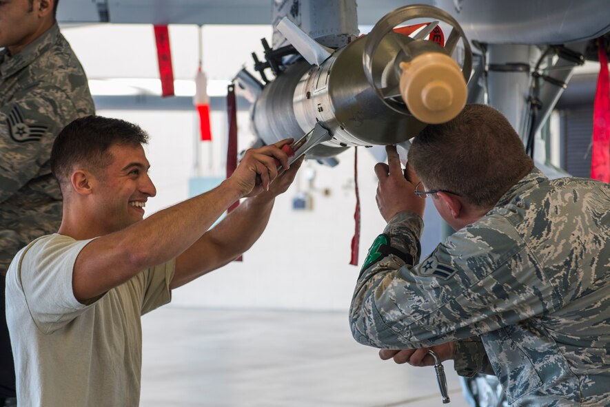 U.S. Air Force Senior Airman Vincent Mattiello, left, and Airman 1st Class Keegan Gibson, 75th Aircraft Maintenance Unit load team members, load an AIM-9 Sidewinder missile onto an A-10C Thunderbolt II during a quarterly weapons load competition Nov. 7, 2014, at Moody Air Force Base, Ga. In addition to weapons loading, Airmen were judged on dress and appearance and job knowledge. (U.S. Air Force photo by Airman 1st Class Dillian Bamman/Released)