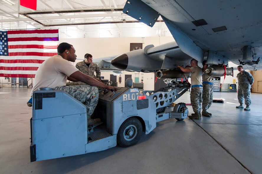 The 74th Aircraft Maintenance Unit weapons load team loads a GBU-12 Paveway II laser-guided bomb during a quarterly weapons load competition Nov. 7, 2014, at Moody Air Force Base, Ga. The team competed against the 75th AMU and finished two minutes ahead of their competition. (U.S. Air Force photo by Airman 1st Class Dillian Bamman/Released)