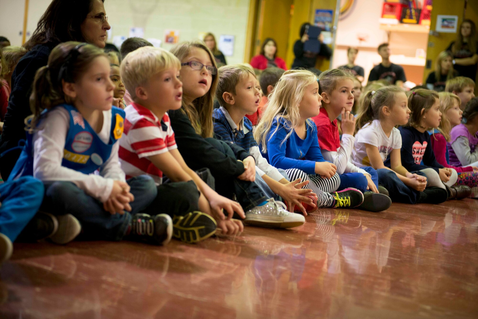 North Plains Elementary School students listen as a story is read to them on Minot Air Force Base, N.D., Nov. 7, 2014. The students, ranging from kindergarten to sixth grade, participated in patriotic events in honor of Veteran’s Day. (U.S. Air Force photo/Airman 1st Class Sahara L. Fales)
