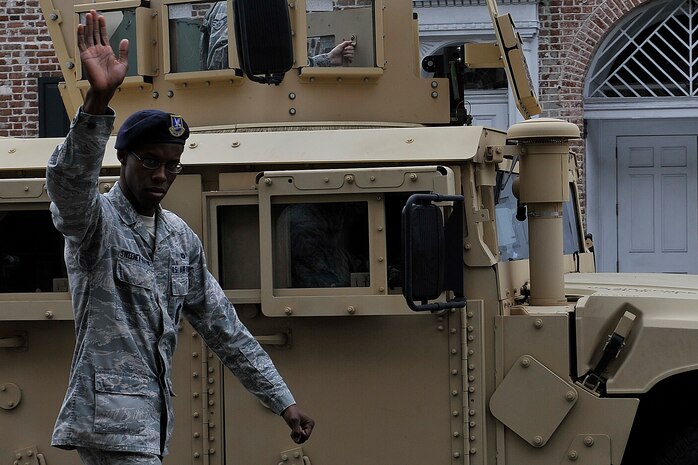 Senior Airman Dante Sweeneyhaynes, 628th Security Forces Squadron installation patrolman, waves to the crowd during the annual Veterans Day Parade Nov. 8, 2014, in Charleston S.C. More than 90 Airmen and Sailors participated in the 1.2 mile parade through historic downtown Charleston. (U.S. Air Force photo/Staff Sgt. Renae Pittman)