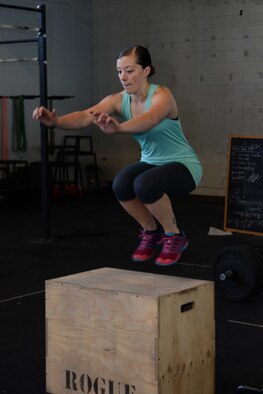 Senior Airman Samantha Rule, 28th Mission Support Group administrator, performs box jumps during a circuit-training workout at the Pride Hangar at Ellsworth Air Force Base, S.D., Nov. 4, 2014. Rule attends classes in Rapid City, S.D. to learn proper form and technique for these exercises, to maximize effectiveness and avoid injuries. (U.S. Air Force photo by Airman 1st Class Rebecca Imwalle/ Released)