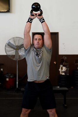 Second Lt. Aaron Jones, 28th Mission Support Group executive officer, performs kettle bell swings during a circuit-training workout at the Pride Hangar at Ellsworth Air Force Base, S.D., Nov. 4, 2014. Jones uses these workouts to increase his overall fitness and combat readiness. (U.S. Air Force photo by Airman 1st Class Rebecca Imwalle/ Released)