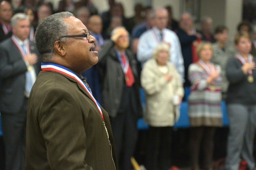 Retired U.S. Army Sgt. 1st Class Timothy Martin, leads fellow veterans, Airmen and civilian members of the Hanscom community in singing the national anthem during the Hanscom Salute to Veterans ceremony at the Hanscom Conference Center Nov. 7. The base held the ceremony to recognize and thank local veterans for their service to the nation. Veterans from World War II to the current campaigns in Iraq and Afghanistan attended the event. (U.S. Air Force photos by Jerry Saslav)