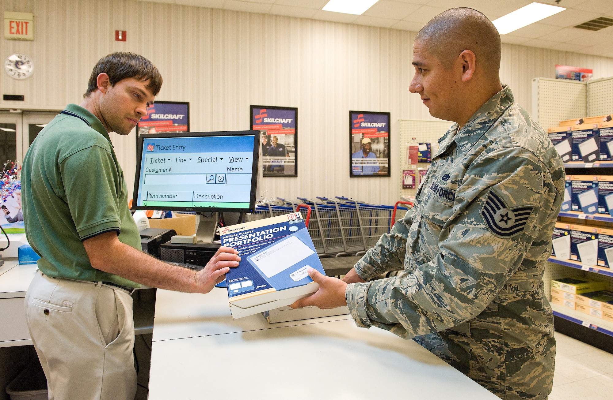 Brian Fredrickson, AbilityOne Base Supply Center retail associate, processes a purchase by Tech. Sgt. Victor Chavez, 436th Maintenance Group AFSO 21 coordinator Oct. 6, 2014, at the Base Supply Center on Dover Air Force Base, Del. Fredrickson, a visually impaired employee of AbilityOne BSC, a division of Blind Industries and Services of Maryland, was recognized as an ability ambassador during the National Disability Employment Awareness Month Luncheon on Oct. 28th at The Landings. (U.S. Air Force photo/Roland Balik)