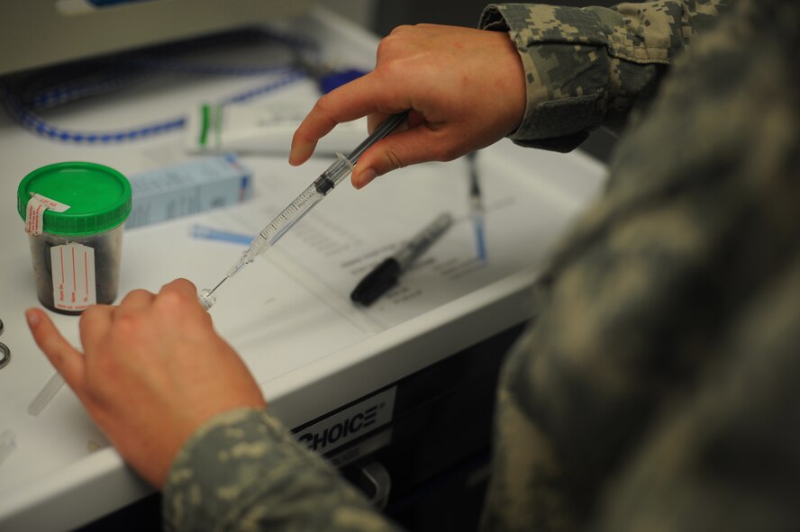 Army Capt. Amanda Jeffries, Chief of Dover Branch Veterinary Services, prepares a shot for a patient October 15, 2014, at the Veterinary Treatment Facility on Dover Air Force Base, Del. The VTF provides preventative medicine, such as rabies and distemper vaccines, to their customers’ pets. (U.S. Air Force photo by Staff Sgt. Elizabeth Morris)