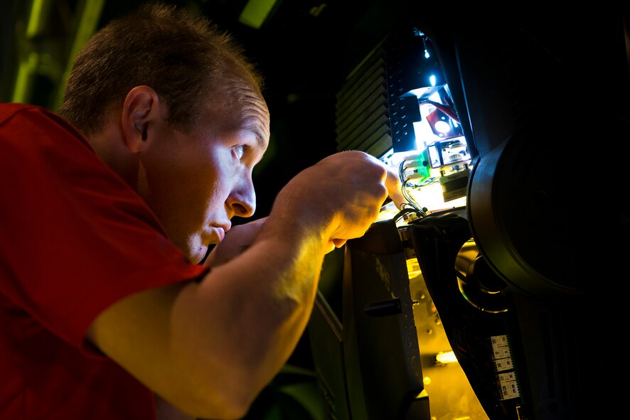 U.S. Air Force Staff Sgt. Blake Whilden, Tops In Blue lighting and technical director, performs preventative maintenance on a lighting fixture Nov. 5, 2014, at the Mathis City Auditorium in Valdosta, Ga. Whilden was troubleshooting a stuck color-wheel, and ultimately determined simple dust-buildup to be the cause. (U.S. Air Force photo by Airman 1st Class Ryan Callaghan/Released)
