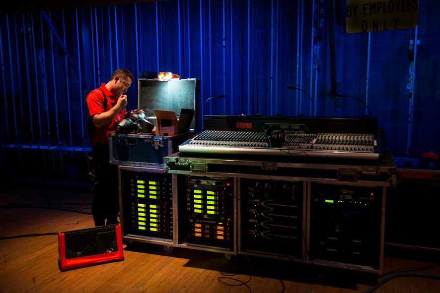 U.S. Air Force Senior Airman Kyle Mergeler, Tops In Blue staging director, fixes a connector on a lighting fixture Nov. 5, 2014, at the Mathis City Auditorium in Valdosta, Ga. As the staging director, Mergeler is responsible for leading a team in safely setting up and tearing down the stage. (U.S. Air Force photo by Airman 1st Class Ryan Callaghan/Released)