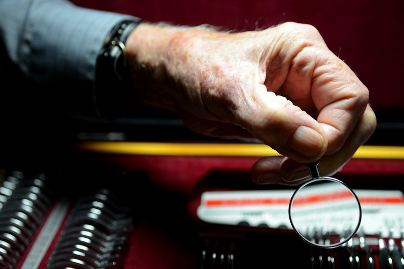 Retired U.S. Air Force Chief Master Sgt. Mark Flockhart selects a lens to insert into a peripheral vision-testing machine at Langley Air Force Base, Va., Nov. 10, 2014. Flockhart is approaching 60 years of combined active duty and civil service to the U.S. Air Force. (U.S. Air Force photo by Airman 1st Class Devin Scott Michaels/Released)