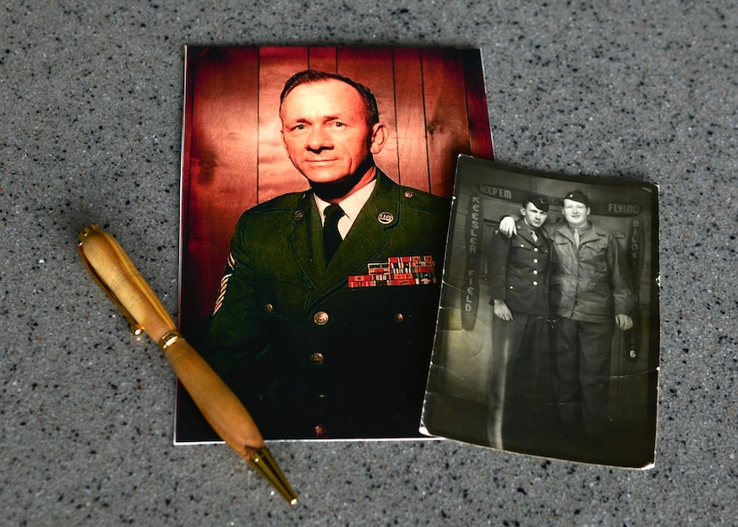 Photos of retired U.S. Air Force Chief Master Sgt. Mark Flockhart from his years of service are displayed along with a wooden pen, which he crafted, at Langley Air Force Base, Va., Nov. 10, 2014. Flockhart graduated Basic Military Training in 1946 and retired in 1974. As a retiree, he enjoyed spending his spare time woodworking, but his hands lost dexterity with age. (U.S. Air Force photo by Airman 1st Class Devin Scott Michaels/Released)