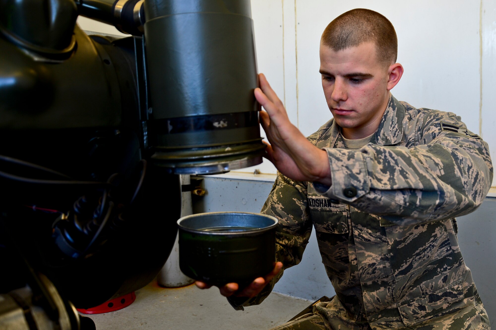 Airman 1st Class Kyle Bradshaw, 48th Civil Engineer Squadron electrical power production journeyman, checks the oil during a daily inspection on an aircraft arresting system at Royal Air Force Lakenheath, England, Nov. 4, 2014. Bradshaw was nominated for a Liberty Spotlight because he displays the core value of Excellence in All We Do. (U.S. Air Force photo by Airman 1st Class Erin R. Babis/Released)